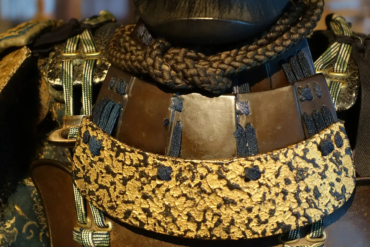 Close view of an Edo-period samurai armour with gold lacquered plates and braided silk cords